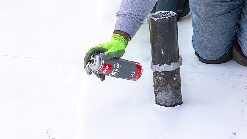 Close up of contractor spraying EverGuard® TPO Primer onto a commercial roof.